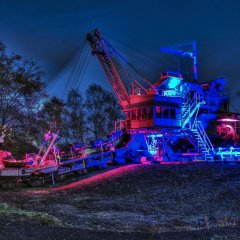 Industriekultur bei Nacht. Die Bergbaubagger des Freilichtmuseums werden kunstvoll illuminiert und bilden eine tolle Kulisse für die Aktionen.